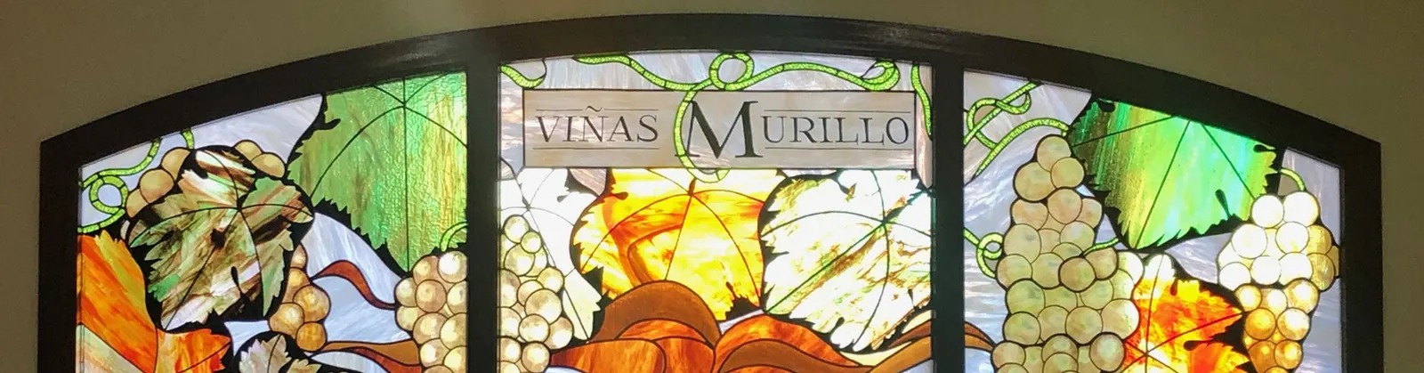 Vidriera de colores con racimos y el nombre Viñas Murillo